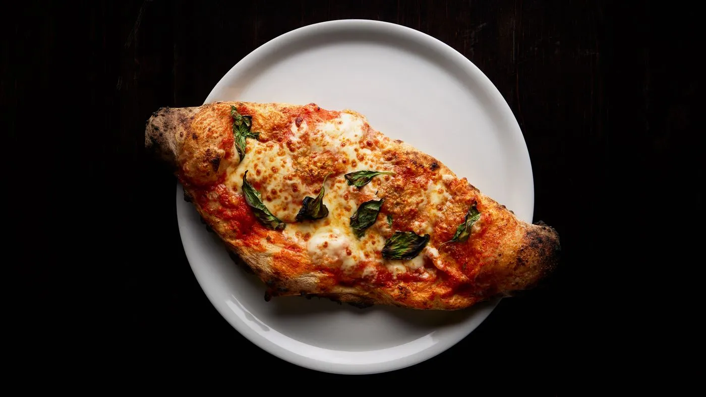 Folded calzone with melted mozzarella and basil