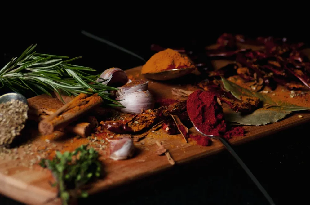 Fresh herbs, spices and garlic laid out for prep