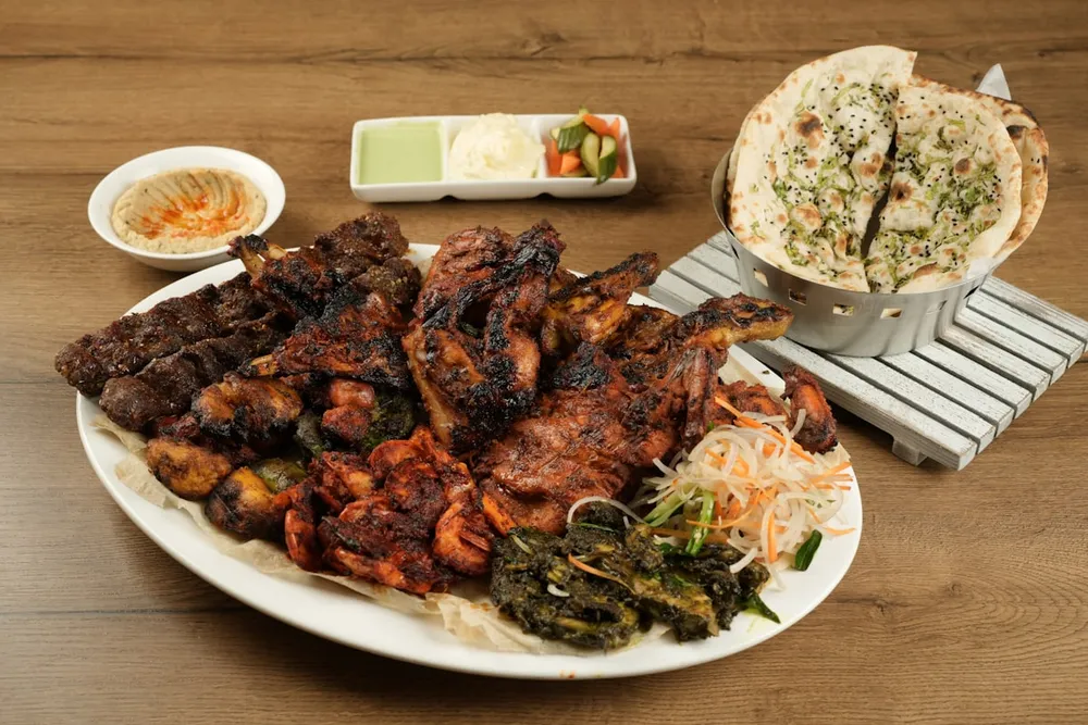 Mixed grill platter with flatbread, hummus and dips
