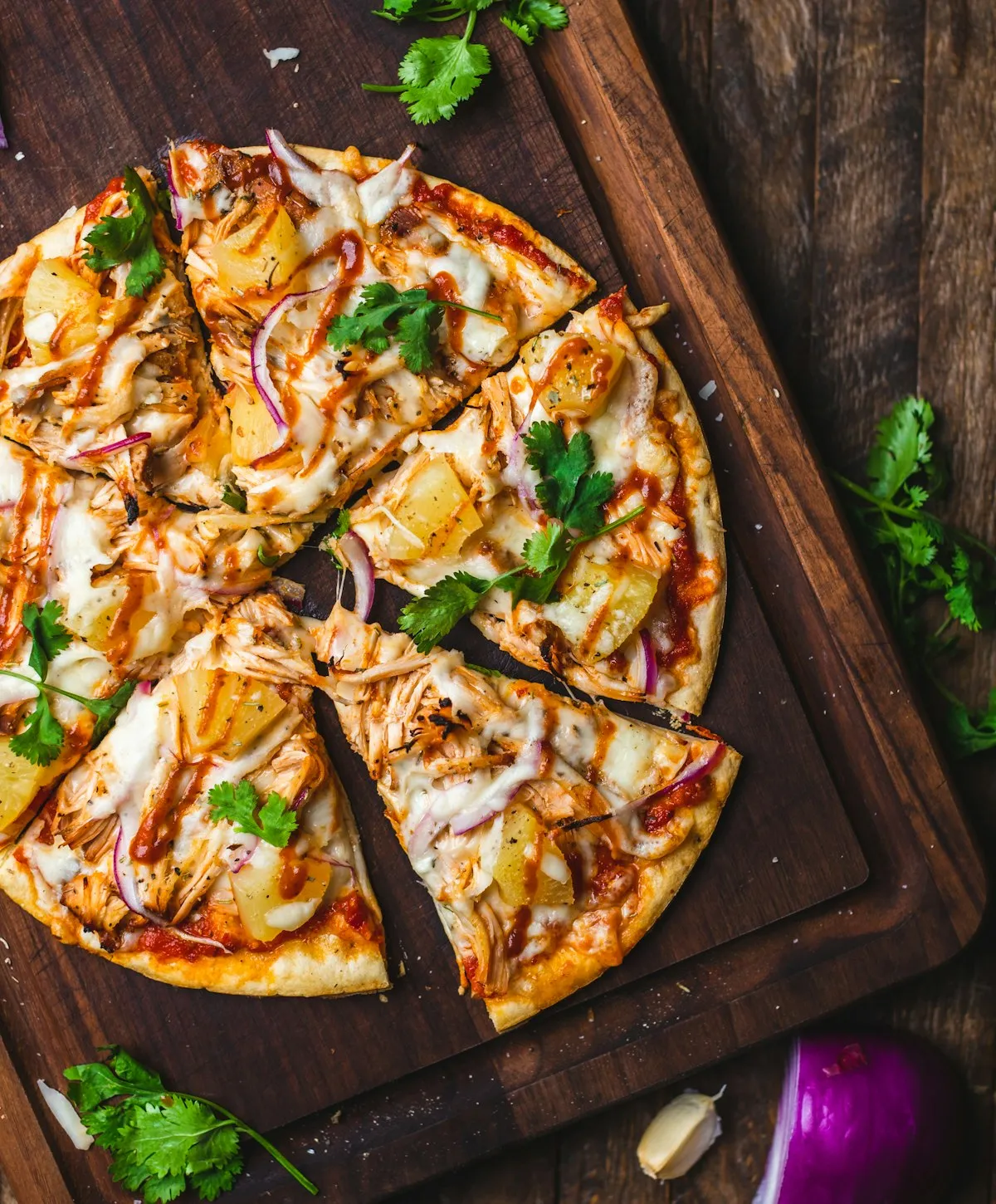 Sliced pizza topped with melted cheese and fresh herbs